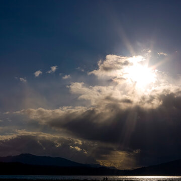 Clearing black storm clouds and a sunburst.