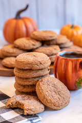 Baked cookies and warm coffee next to decorative pumpkins in a cozy autumn setting