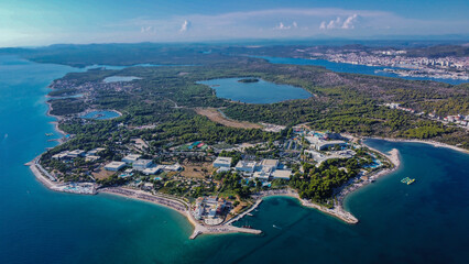 Obraz premium Sprawling seaside resort complex nestled on a lush, green peninsula, where a vibrant community of beaches