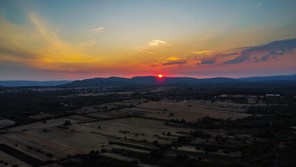 Dramatic sunset over rolling farmland and hills in the Croatian or European countryside, showcasing vibrant orange and red skies