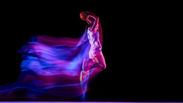 Basketball player flying upward with glowing ball and colorful motion blur. Concept of modern sports branding, energy advertising, fitness motivation, and digital lifestyle visuals.