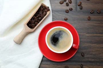 Fotobehang Café Aromatic coffee in cup and beans on wooden table, flat lay  © New Africa