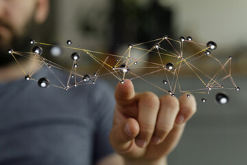 Close-up of a hand pointing at a complex network, symbolizing connection and global data.