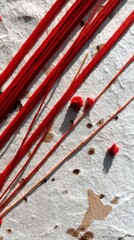 Vibrant red threads and yarn are beautifully displayed on textured paper, highlighting their rich colors and unique textures, ideal for artistic and design applications