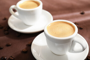 Aromatic coffee in cups and beans on table, closeup