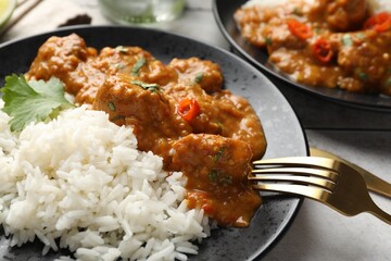 Chicken tikka masala with rice served on light tiled table, closeup
