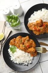 Chicken tikka masala with rice served on light tiled table, flat lay