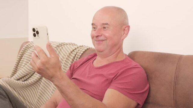 Mature man scrolling smartphone, surprised by online news, sitting indoors, wasting time, casual clothing, emotional face