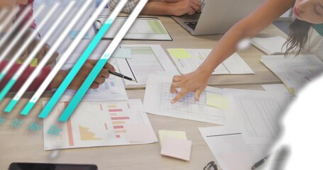 Man pointing pen and woman tapping tablet in business meeting, animating charts analyzing sales - Powered by Adobe