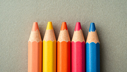 Close up colorful crayons lined up against a textured surface