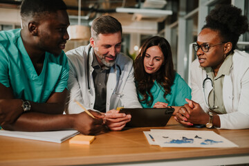Diverse medical team collaborating using digital tablet