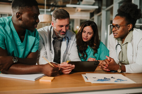 Diverse medical team collaborating using digital tablet