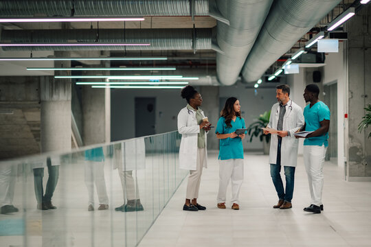 Medical team collaborating in modern hospital corridor - Powered by Adobe
