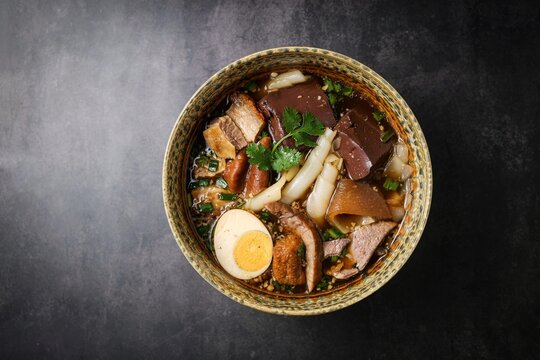 Chinese rolled noodles with crispy pork and egg in black soup,Rolled Rice Noodles in Five-spices Broth , Chinese noodles, thai called kuay jap