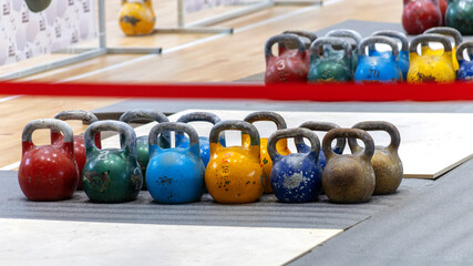 Old kettlebells stand in a row before a kettlebell lifting competition.