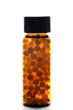 Homeopathic pills in a small amber vial
