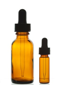 Close-up of two empty dropper bottles on a white background.