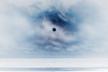 Setting sun over vast ocean in a cloud filled sky