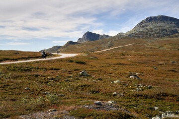  "Motorbikes Riding Away from Gaustatoppen Mountain at Sunset during Scenic Highway Adventure in Telemark, Norway - Breathtaking Panorama of Motorcycles on Road Trip along Mountaintops and Norway
