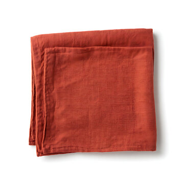 Folded burnt orange linen napkin on a white background