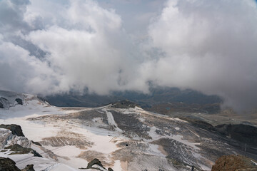Cloudy day over the Swiss Alps, viewed from Glacier Paradise in Zermatt, with dramatic peaks and misty alpine scenery