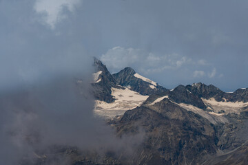 Cloudy day over the Swiss Alps, viewed from Glacier Paradise in Zermatt, with dramatic peaks and misty alpine scenery