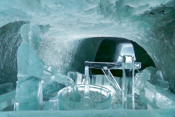 Intricate ice sculpture of a wolf and man displayed inside Glacier Paradise, Zermatt, with glacial surroundings and alpine ambiance.