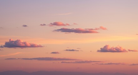 Scattered cumulus clouds appear against a pastel horizon during the soft light of evening.