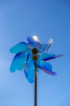 Colorful pinwheel spinning against a clear blue sky during a sunny day