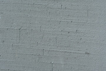 Close-up of a grey concrete surface with a different structure and grainy texture.