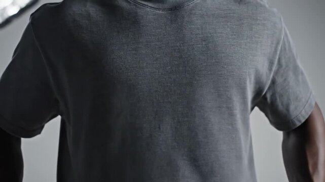 Timeless Tee: A simple, gray t-shirt drapes elegantly on a human, in this studio shot emphasizing the beauty of subtle details.