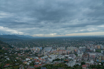 Fototapeta premium A vast, high-angle panoramic shot captures the dense urban area of Lezha, Albania, transitioning into the extensive cultivated coastal plain and valley beyond, all beneath a sweeping, moody sky heavy 