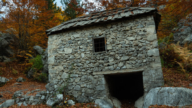 A compelling close-up horizontal shot of a traditional, rustic stone building, likely an old mill or shepherd's hut, situated in the mountainous terrain of Tropoje, Albania.(Mulliri i vjeter Valbone)