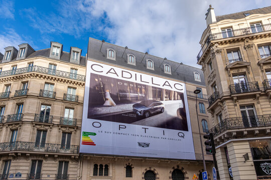 Paris, France - 18 novembre 2025: Affiche publicitaire g&eacute;ante en Fran&ccedil;ais pour la voiture &eacute;lectrique Cadillac Optiq sur les &eacute;chafaudages des travaux de restauration de la fa&ccedil;ade d'un immeuble parisien