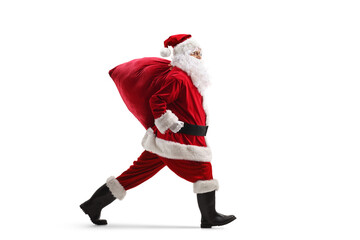 Full length profile shot of Santa Claus running with a sack of presents