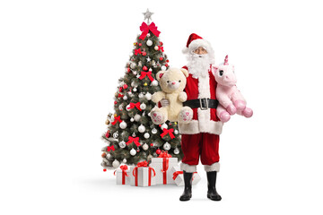 Santa Claus holding toys in front of a christmas tree