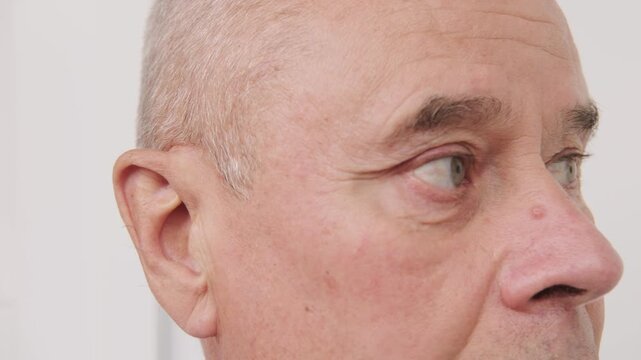 bald man hearing or listening deeply, ear with pained expression, discomfort loud noise, age-related hearing loss, Emotional portrait, discomfort loud noise, Environmental noise, reaction loud sounds