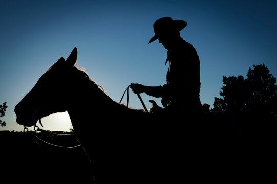 Santa Fe, New Mexico, United States. Cowboy seated on his horse on the trail at twilight