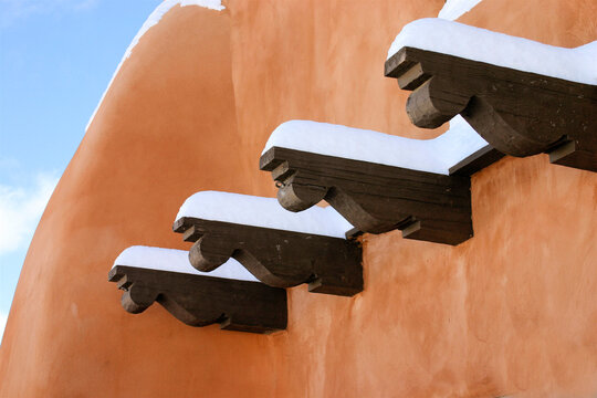 Santa Fe, New Mexico, USA. Adobe building with snow on top of wooden vigas in the winter. 