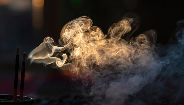 Incense sticks burning creating wisps of smoke.