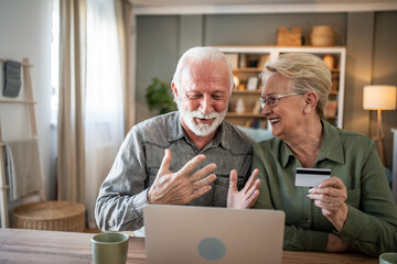 Senior couple enjoying online shopping using laptop and credit card