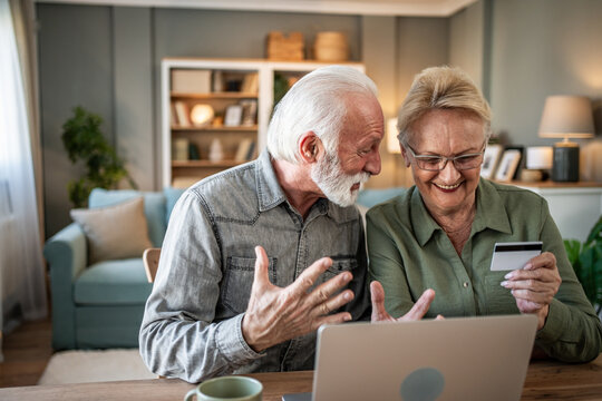 Senior couple enjoying online shopping with credit card at home