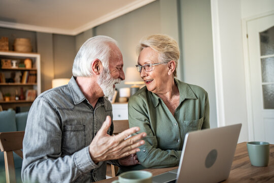 Senior couple sharing happy moments with laptop at home