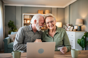 Senior couple enjoying online shopping using laptop and credit card