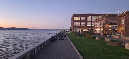  A sunset view of the Hudson River from the peir of a corporate park with repurposed red brick,...
