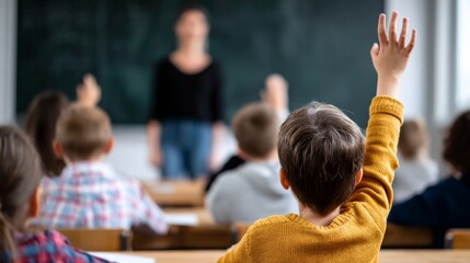 Child raising hand in classroom, actively participating in primary school education and learning from teacher