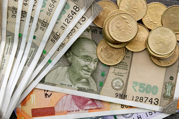 Close up top view of Indian rupee notes (INR) and coins of different values. Concept of cash savings, financial profit and security, Indian economy.