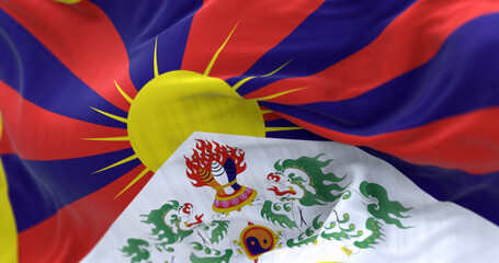 Tibetan flag waving outdoors with snow lions and rising sun symbolizing freedom