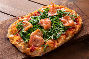Pinsa romana condita con salmone affumicato e rucola, cibo italiano 