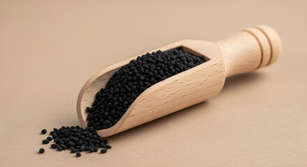 Nigella seeds in wooden scoop isolated on white background